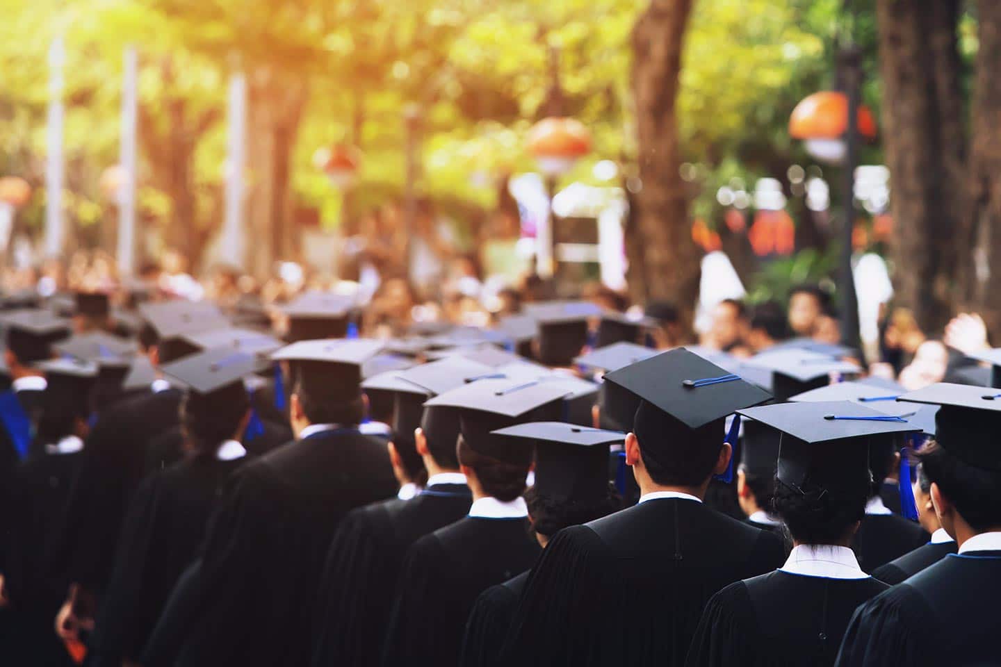 Graduates in caps and gowns walking in line at a commencement ceremony