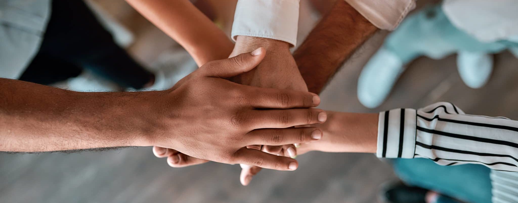 Five people stacking their hands one on top of another