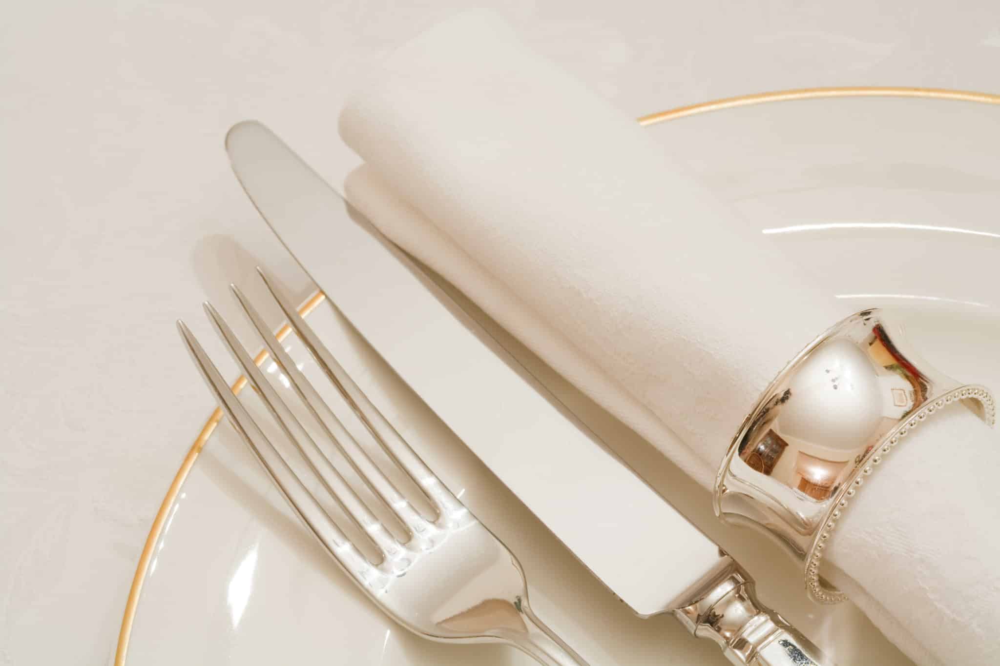 Place setting with cutlery, plate and napkin on a damask tablecloth