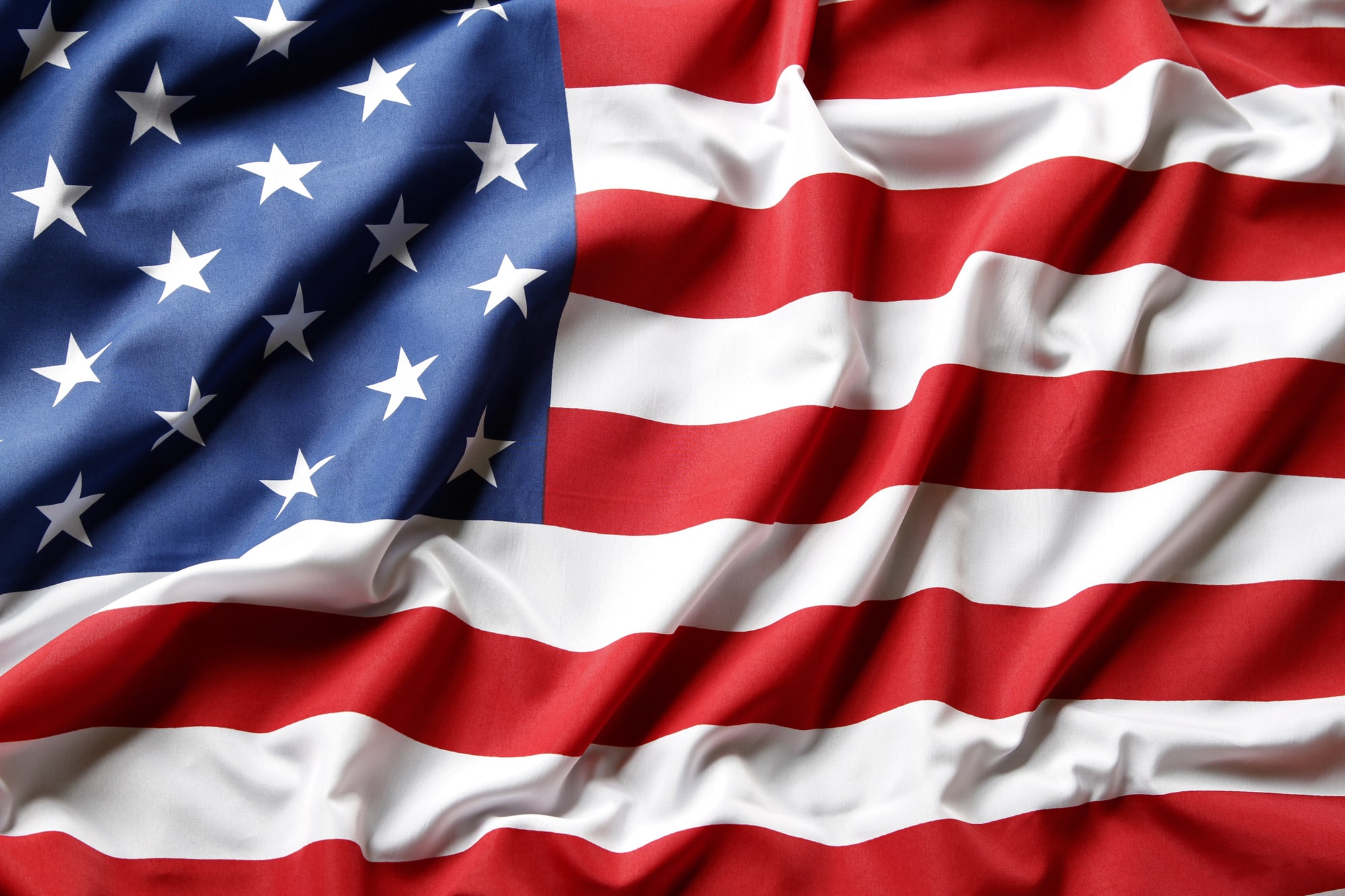 A close-up of the United States flag, its stars and stripes in soft folds