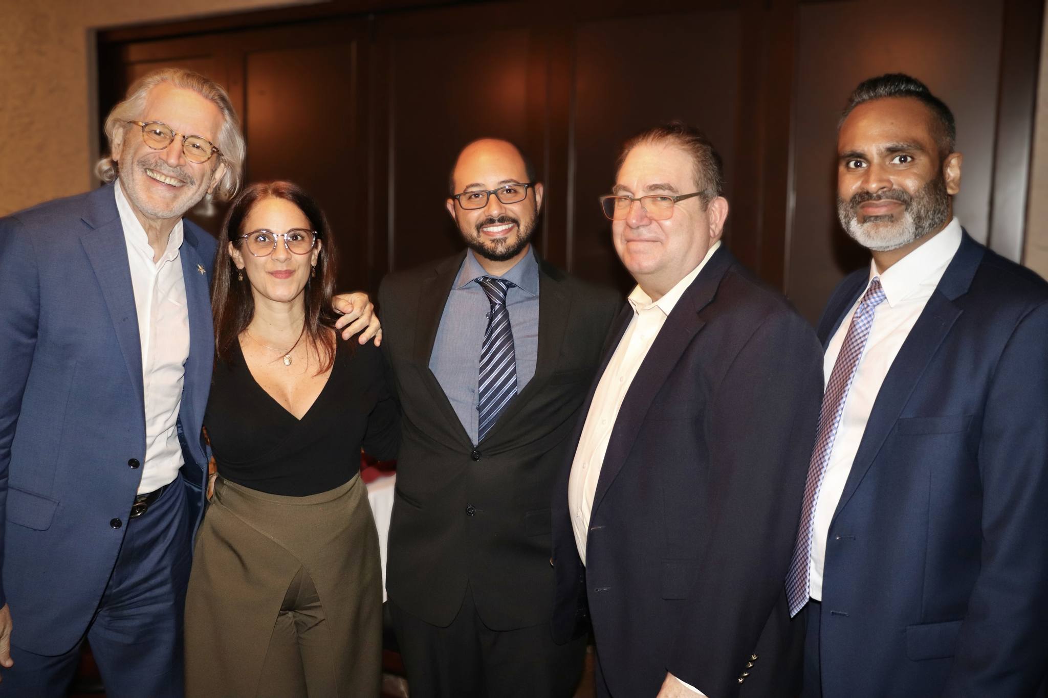 Five guests standing together at a Trustbridge evening fundraising event