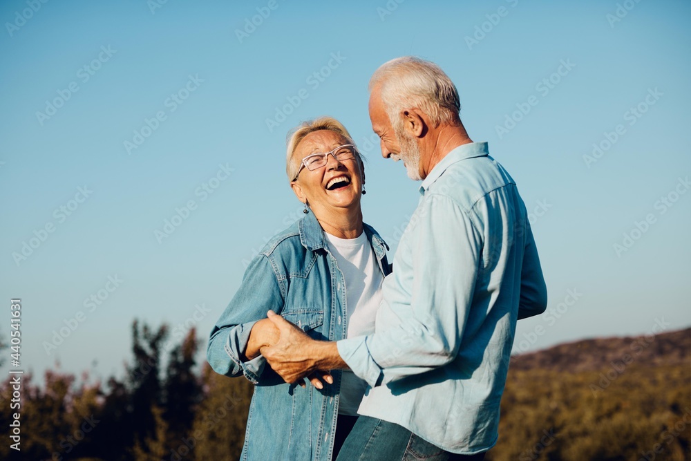 An older couple laughing together outdoors