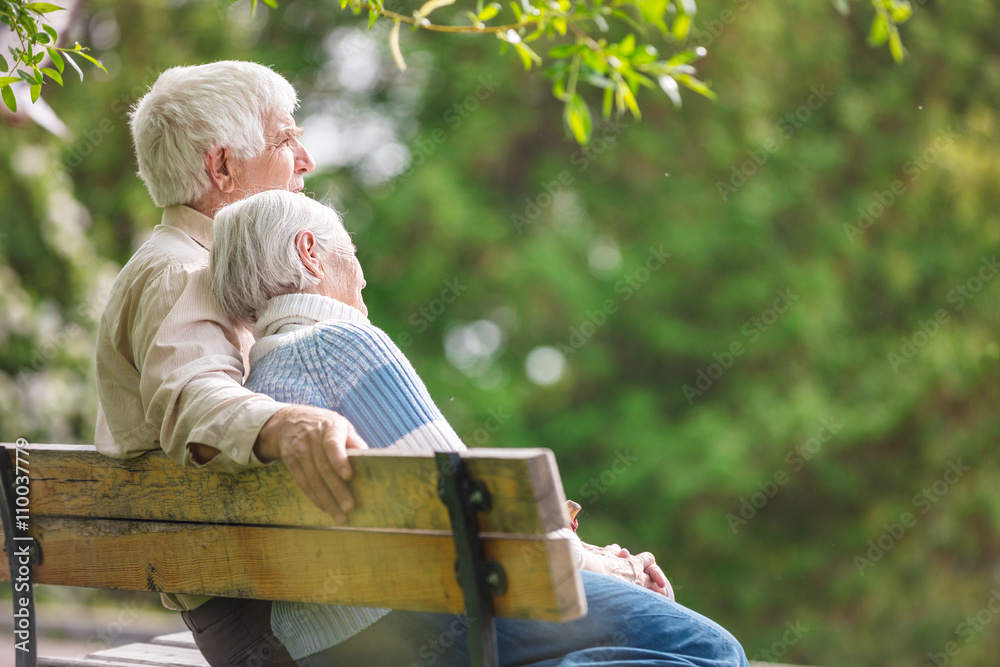 A couple sitting together on a park bench