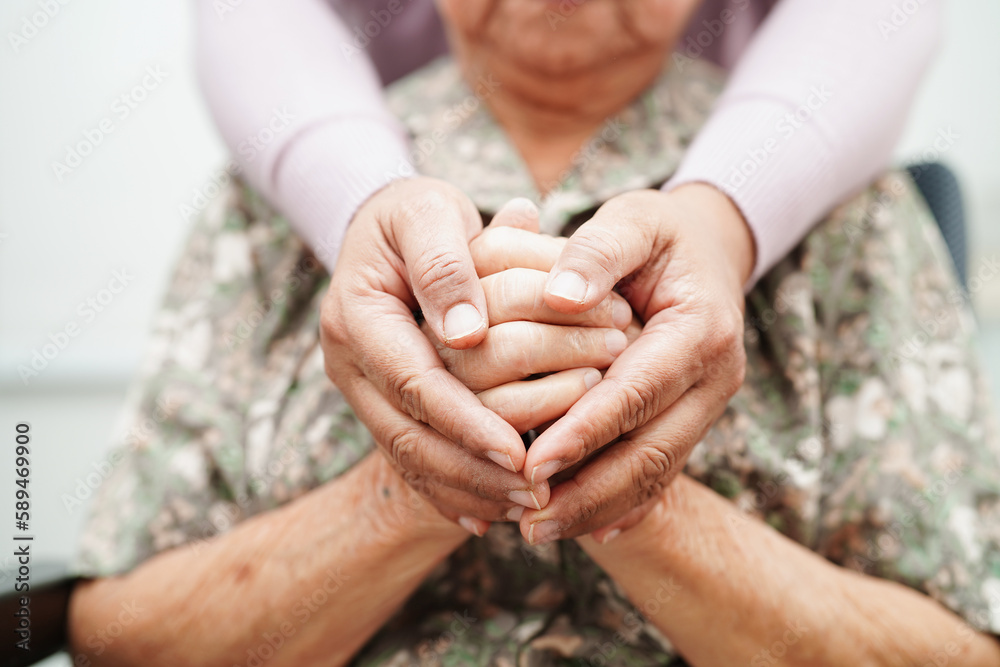A caregiver holding a patient's hands